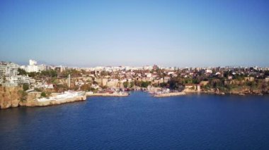 Antalya 'da Antalya Körfezi' nin güneşli bir günde insansız hava aracının yüksek noktasından havadan çekilmiş fotoğrafı. Kuşlardan inanılmaz bir şehir manzarası. Güzel kasaba ve deniz yamaçları üzerinde uçuyorlar.