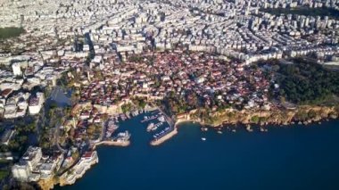 Antalya 'da Antalya Körfezi' nin güneşli bir günde insansız hava aracının yüksek noktasından havadan çekilmiş fotoğrafı. Kuşlardan inanılmaz bir şehir manzarası. Güzel kasaba ve deniz yamaçları üzerinde uçuyorlar.