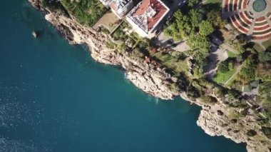 Antalya 'da Antalya Körfezi' nin güneşli bir günde insansız hava aracının yüksek noktasından havadan çekilmiş fotoğrafı. Kuşlardan inanılmaz bir şehir manzarası. Güzel kasaba ve deniz yamaçları üzerinde uçuyorlar.