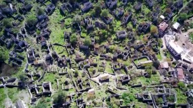 Olludeniz yakınlarındaki dünyaca ünlü Kayakoy hayalet kasabasının insansız hava aracı görüntüsü, Fethiye. Tepenin güzel yeşil yamacındaki antik şehir..