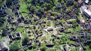 Olludeniz yakınlarındaki dünyaca ünlü Kayakoy hayalet kasabasının insansız hava aracı görüntüsü, Fethiye. Tepenin güzel yeşil yamacındaki antik şehir..
