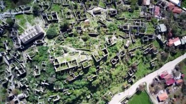 Olludeniz yakınlarındaki dünyaca ünlü Kayakoy hayalet kasabasının insansız hava aracı görüntüsü, Fethiye. Tepenin güzel yeşil yamacındaki antik şehir..