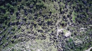 Olludeniz yakınlarındaki dünyaca ünlü Kayakoy hayalet kasabasının insansız hava aracı görüntüsü, Fethiye. Tepenin güzel yeşil yamacındaki antik şehir..