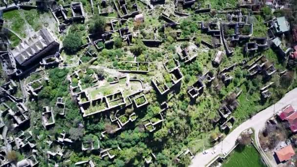 世界的に有名なカヤックの幽霊の町のドローンビューに近いOludeniz Fethiye 丘の美しい緑の斜面に古い古代都市 — ストック動画