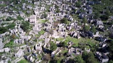 Olludeniz yakınlarındaki dünyaca ünlü Kayakoy hayalet kasabasının insansız hava aracı görüntüsü, Fethiye. Tepenin güzel yeşil yamacındaki antik şehir..