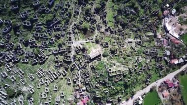 Olludeniz yakınlarındaki dünyaca ünlü Kayakoy hayalet kasabasının insansız hava aracı görüntüsü, Fethiye. Tepenin güzel yeşil yamacındaki antik şehir..