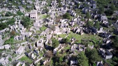 Olludeniz yakınlarındaki dünyaca ünlü Kayakoy hayalet kasabasının insansız hava aracı görüntüsü, Fethiye. Tepenin güzel yeşil yamacındaki antik şehir..