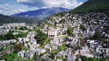 Olludeniz yakınlarındaki dünyaca ünlü Kayakoy hayalet kasabasının insansız hava aracı görüntüsü, Fethiye. Tepenin güzel yeşil yamacındaki antik şehir..