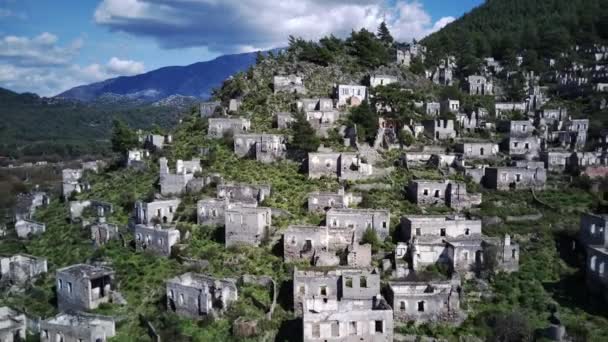 世界的に有名なカヤックの幽霊の町のドローンビューに近いOludeniz Fethiye 丘の美しい緑の斜面に古い古代都市 — ストック動画