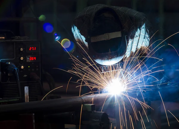 Koruyucu maskeli, kaynak yapan bir işçi.
