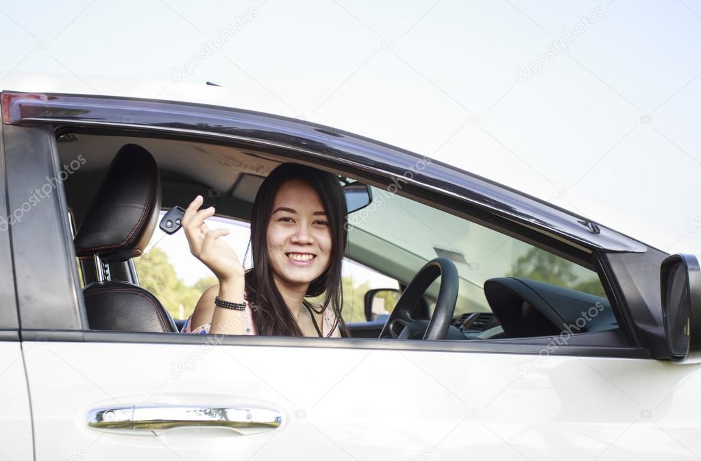 Asian car driver woman smiling showing new car keys