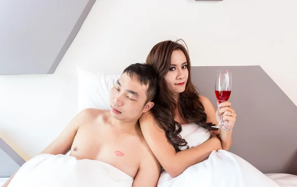 Jovem casal se divertindo em uma cama — Fotografia de Stock