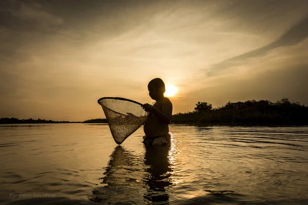 Jongen vissen op de rivier. — Stockfoto