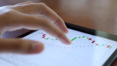 Yatırımcılar hisse senedi ticareti yapıyor. Akıllı telefonlar ve bilgisayarlar kullanarak