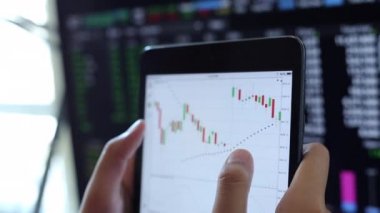 Yatırımcılar hisse senedi ticareti yapıyor. Akıllı telefonlar ve bilgisayarlar kullanarak