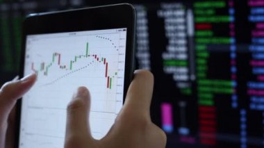 Yatırımcılar hisse senedi ticareti yapıyor. Akıllı telefonlar ve bilgisayarlar kullanarak