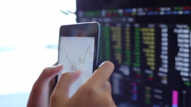 Yatırımcılar hisse senedi ticareti yapıyor. Akıllı telefonlar ve bilgisayarlar kullanarak