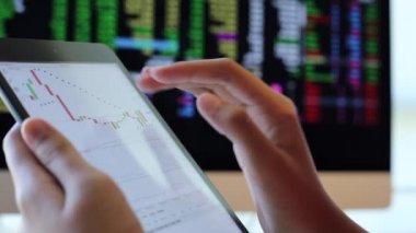 Yatırımcılar hisse senedi ticareti yapıyor. Akıllı telefonlar ve bilgisayarlar kullanarak