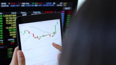 Yatırımcılar hisse senedi ticareti yapıyor. Akıllı telefonlar ve bilgisayarlar kullanarak