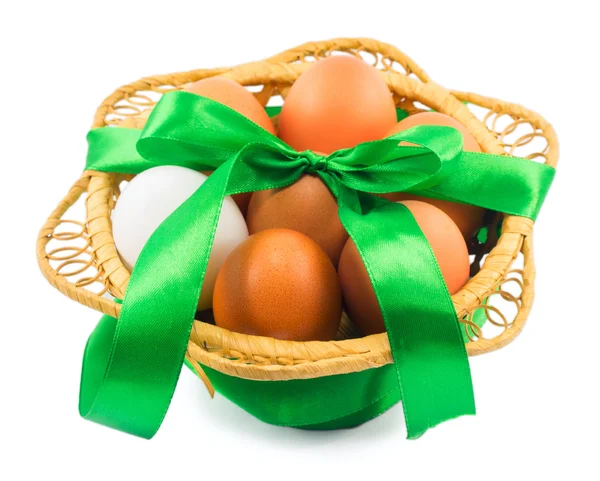 Basket with eggs and green ribbon isolated on white background — Stock Photo, Image