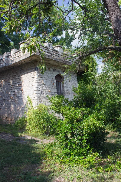 La antigua torre de piedra con una ventana arqueada en el jardín —  Fotos de Stock