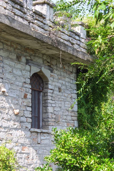 La antigua torre de piedra con una ventana arqueada en el jardín —  Fotos de Stock