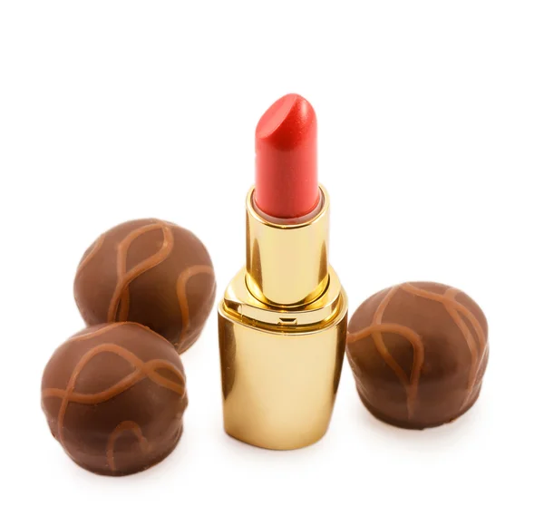 Lápiz labial dorado y caramelos de chocolate aislados sobre fondo blanco —  Fotos de Stock