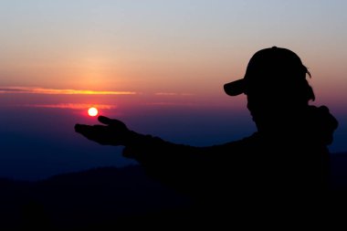 Güneşten sonra el ele tutuşan adam silueti.