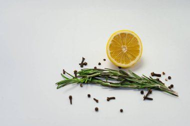 Karanfilli limonlar ve beyaz arka planda taze biberiye. Metin için yer.