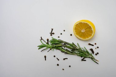 Karanfilli limonlar ve beyaz arka planda taze biberiye. Metin için yer.