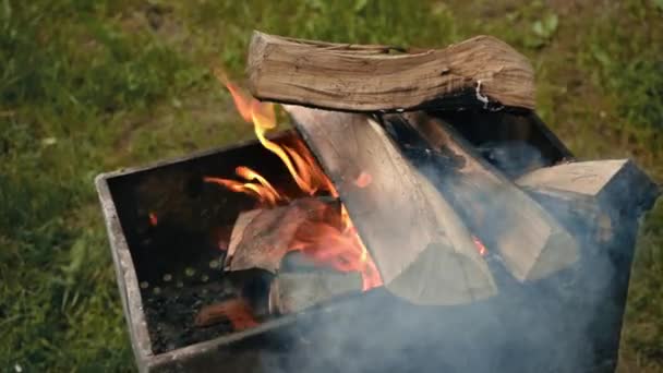 Feu brûlant dans le gril. Au ralenti. Burning Wood in the Grill. Camping le week-end. Préparation des charbons pour la cuisson sur le gril. Beau mouvement de flamme de feu vif. Fond flou. 4k — Video