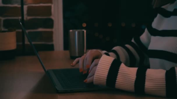 Close-up Nas mãos, menina em uma camisola listrada tipos no teclado à noite, trabalhar à noite. — Vídeo de Stock