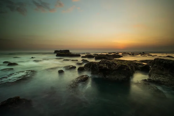 惊人的海景为背景 岩石和石头 移动的水 晴朗的天空 地平线上的太阳景观背景 慢速快门速度 集中精神Mengening海滩 印度尼西亚巴厘 — 图库照片