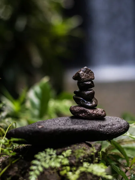 Balance stones in tropical forest. Peaceful nature. Background with blurred waterfall. Beatiful tropical landscape. Vertical layout. Selected focus. Tibumana waterfall in Bali, Indonesia — Stock Image Balance Stones Tropical Forest Peaceful Nature Background Blurred Waterfall Beatiful Stock Image