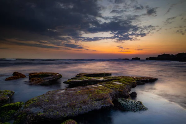 平静的海洋长期暴露 巨石在海浪的神秘薄雾中飘扬 自然背景的概念 日落背景 多云的天空 集中精神Mengening海滩 印度尼西亚巴厘 — 图库照片