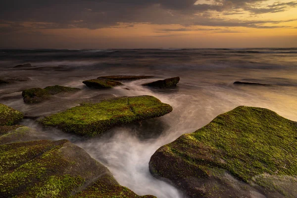 平静的海洋长期暴露 在海浪的神秘云雾中 石子被苔藓覆盖着 自然背景的概念 日落背景 集中精神Mengening海滩 印度尼西亚巴厘 — 图库照片