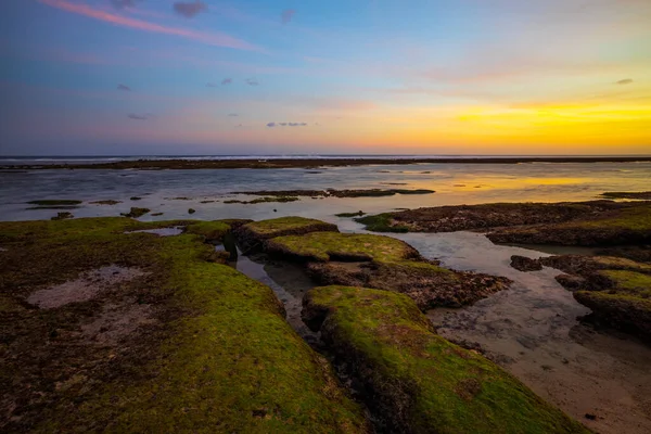 海景为背景 日落时间 岩石和石头 有绿色海藻和苔藓的石头 晴朗的天空 慢速快门速度 集中精神印度尼西亚巴厘Melasti海滩 — 图库照片