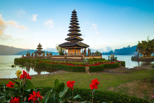 巴厘岛的Pura Ulun Danu Bratan寺庙 美丽的巴厘寺庙 巴厘地标 多云的天空 水的反射开红花的前景 Bratan Lake — 图库照片