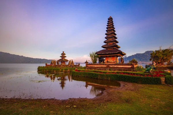 Bali adasındaki Pura Ulun Danu Bratan tapınağı. Güzel bale tapınağı. Bali 'nin simgesi. Bulutlu gökyüzü. Su yansıması. Yeşil çimenli ön plan. Bratan Gölü, Bedugul, Bali, Endonezya