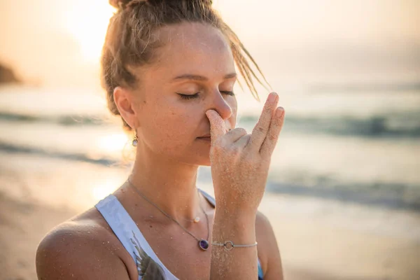Kadının yüzü kapalı. Yogi kadın Nadi Shodhana Pranayama çalışıyor, Alternatif Burun Solunumu. Nefes egzersizi. Kişisel bakım konsepti. Stres ve endişe giderici. Yoga inzivası. Thomas Sahili, Bali