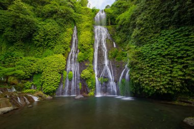 Gizli şelale. Güzel tropikal bir manzara. Doğa geçmişi. Macera ve seyahat konsepti. Çevre konsepti. Yavaş deklanşör hızı, hareket fotoğrafçılığı. Banyumala Şelalesi, Bali, Endonezya