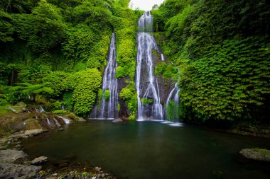 Yüzmek için kocaman göleti olan bir şelale. Tropik bir manzara. Doğa geçmişi. Seyahat macerası konsepti. Çevre konsepti. Yavaş deklanşör hızı, hareket fotoğrafçılığı. Banyumala Şelalesi, Bali Endonezya