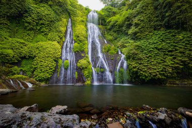 Şelale manzarası. Tropik bir manzara. Doğa geçmişi. Macera ve seyahat konsepti. Doğal ortam. Yavaş deklanşör hızı, hareket fotoğrafçılığı. Banyumala Şelalesi, Bali, Endonezya