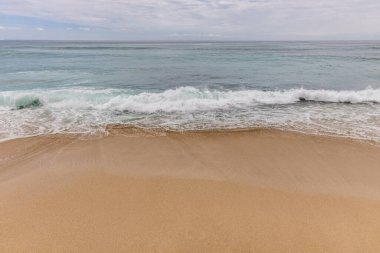 Deniz manzaralı arka plan. Kumsal, süt köpüğü dalgaları, mavi okyanus. Manzaralı su manzarası. Ufuk çizgisi. Doğa ve çevre kavramı. Gün ışığı. Uzayı kopyala Rüya Diyarı Sahili, Bali Endonezya