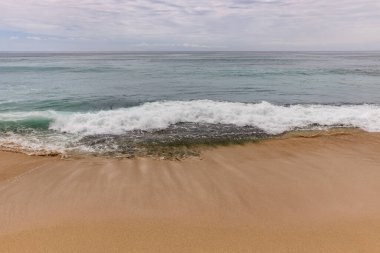 Deniz manzaralı arka plan. Kumsal, süt köpüğü dalgaları, mavi okyanus. Manzaralı su manzarası. Ufuk çizgisi. Doğa ve çevre kavramı. Gün ışığı. Uzayı kopyala Rüya Diyarı Sahili, Bali Endonezya