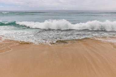 Deniz manzaralı arka plan. Kumsal, süt köpüğü dalgaları, mavi okyanus. Manzaralı su manzarası. Ufuk çizgisi. Doğa ve çevre kavramı. Gün ışığı. Uzayı kopyala Rüya Diyarı Sahili, Bali Endonezya
