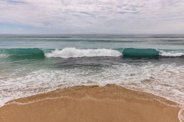 Deniz manzaralı arka plan. Kumsal, süt köpüğü dalgaları, mavi okyanus. Manzaralı su manzarası. Ufuk çizgisi. Bulutlu gökyüzü. Doğa ve çevre kavramı. Gün ışığı. Uzayı kopyala Rüya Diyarı Sahili, Bali Endonezya