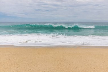 Deniz manzaralı arka plan. Kumsal, süt köpüğü dalgaları, mavi okyanus. Manzaralı su manzarası. Ufuk çizgisi. Bulutlu gökyüzü. Doğa ve çevre kavramı. Gün ışığı. Uzayı kopyala Rüya Diyarı Sahili, Bali Endonezya