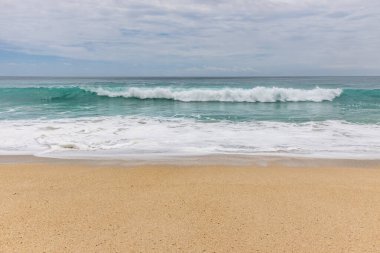 Deniz manzaralı arka plan. Kumsal, süt köpüğü dalgaları, mavi okyanus. Manzaralı su manzarası. Ufuk çizgisi. Bulutlu gökyüzü. Doğa ve çevre kavramı. Gün ışığı. Uzayı kopyala Rüya Diyarı Sahili, Bali Endonezya
