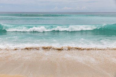 Deniz manzaralı arka plan. Kumsal, süt köpüğü dalgaları, mavi okyanus. Manzaralı su manzarası. Ufuk çizgisi. Doğa ve çevre kavramı. Gün ışığı. Uzayı kopyala Rüya Diyarı Sahili, Bali Endonezya